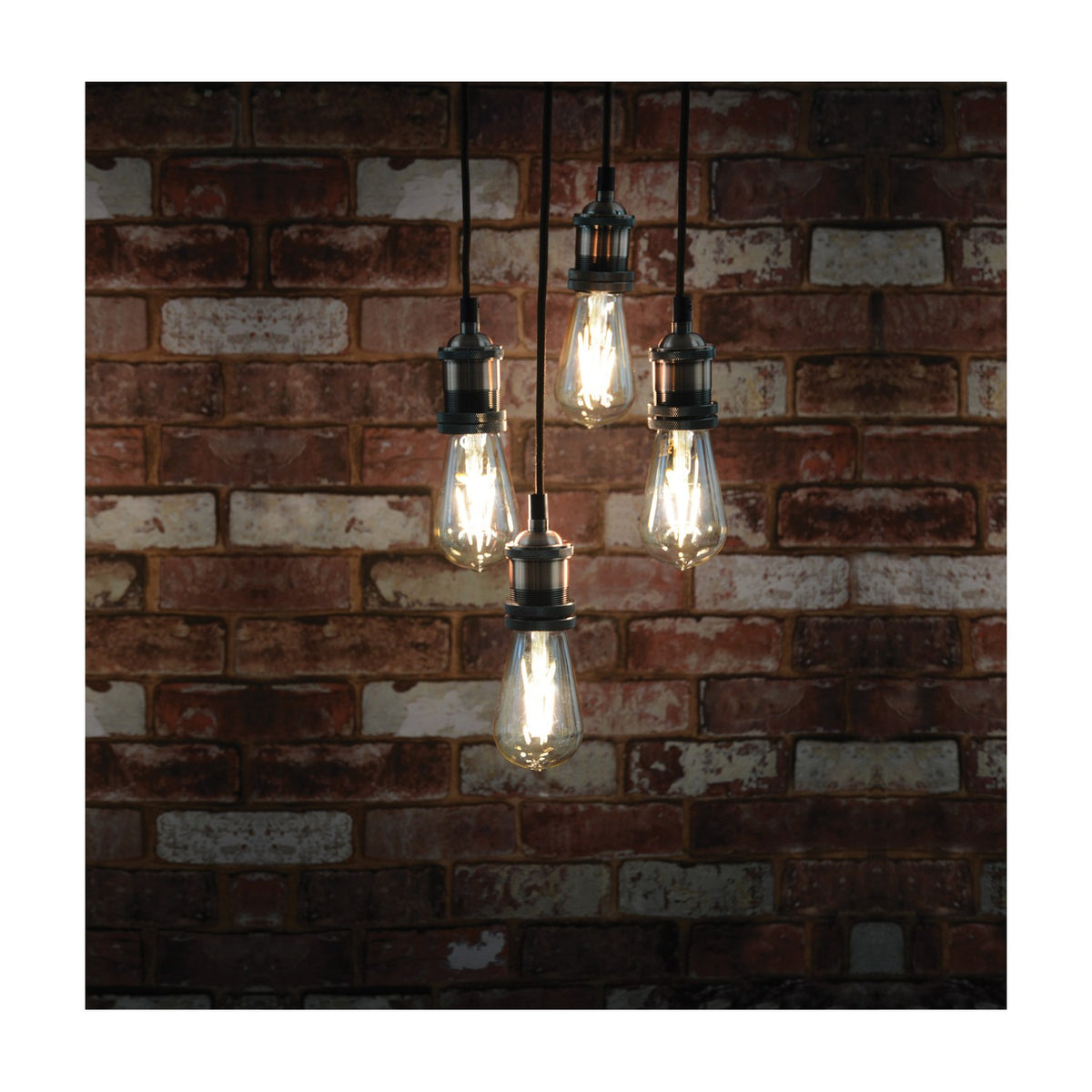 LYYT 4-light pendant set with antique copper lamp holders and Edison filament bulbs on black braided cables, hanging against an exposed red brick wall.