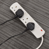 AVSL Mercury 4 gang switched extension lead in white with two black UK plugs connected, resting on a grey carpeted surface with red indicator lit.