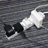 AVSL Mercury 4 gang surge protected extension lead in white with four UK sockets in use, chargers plugged in, shown on a grey striped carpet.