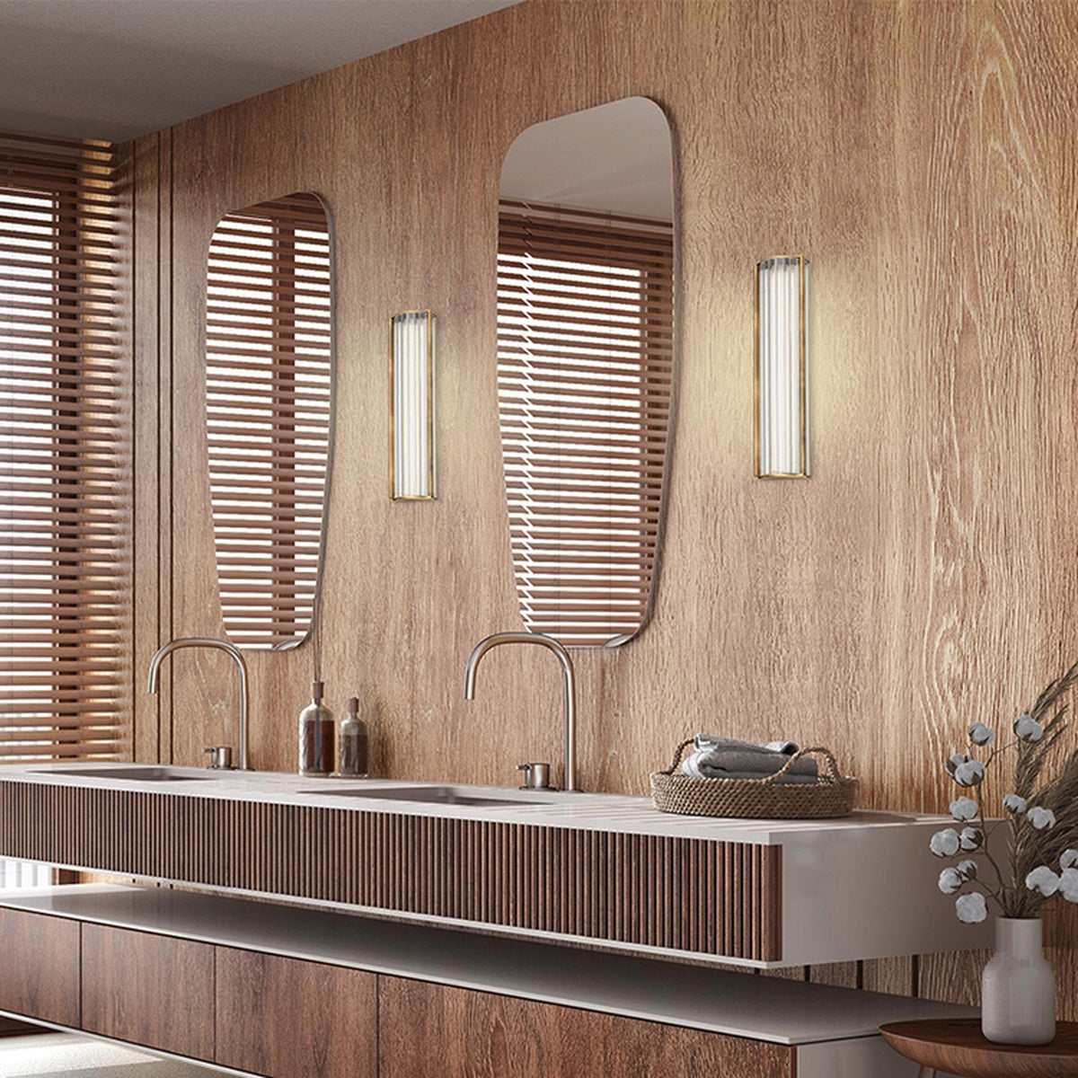 Kalvenne LED Glass Wall Light in satin bronze with ribbed glass shade, shown illuminated beside a mirror in a wood-panelled bathroom vanity setting.