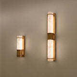 Averna Small LED framed alabaster wall light in brushed brass, shown alongside the larger version, both mounted on a neutral wall with warm ambient glow.