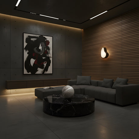 A modern living room with dark walls, a gray sectional, a black marble coffee table, abstract wall art, and soft indirect lighting from the Marea LED Alabaster Wall Light – Matte Black creates a cozy atmosphere.