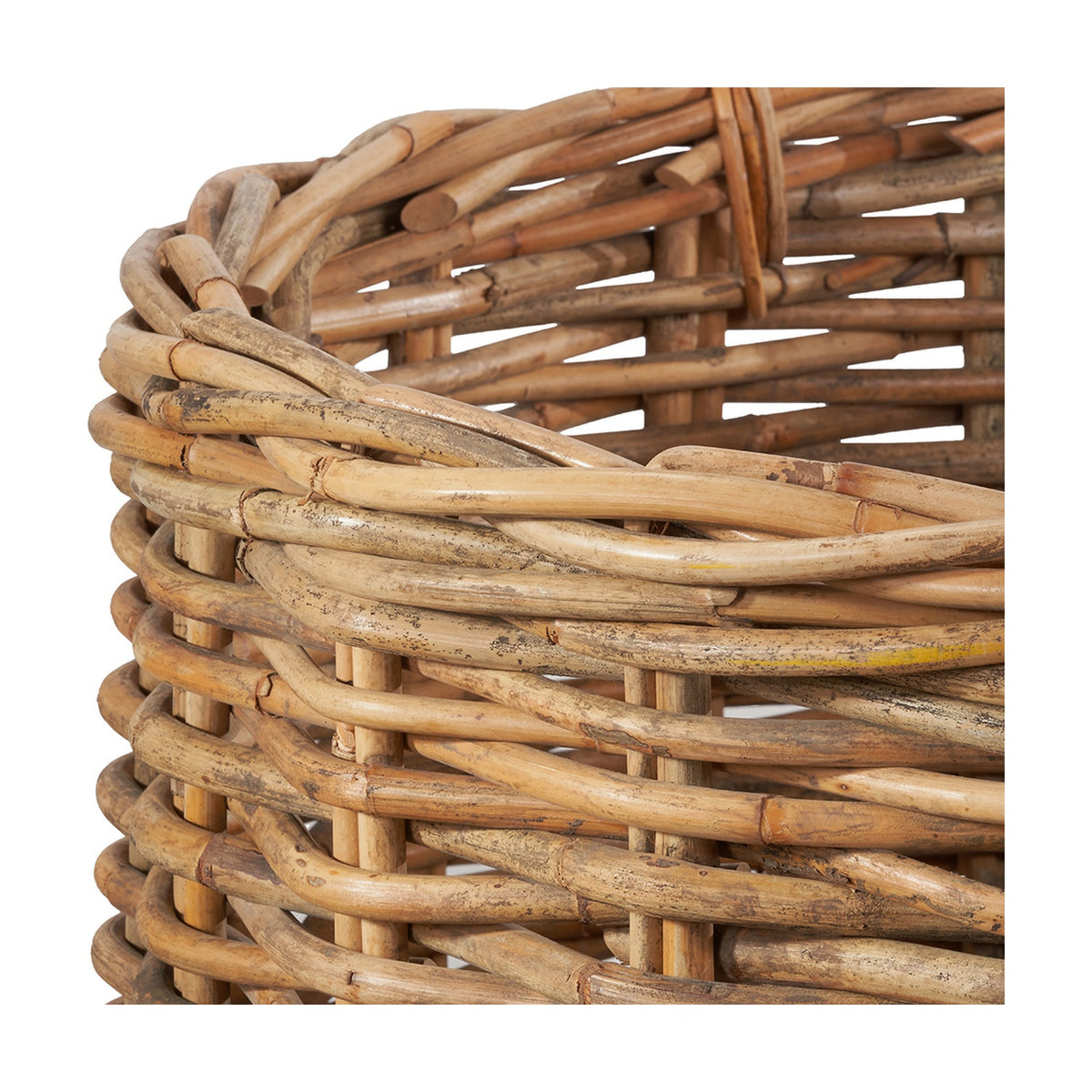 Close-up of a chunky rattan log basket from the Tobs set, showing natural woven cane texture with a wrapped rim and looped handle detail.