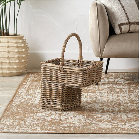 Tobs Grey Kubu Rattan Stair Large Basket, 55cm, with woven handle, shown on a rug beside a beige sofa in a living room setting.
