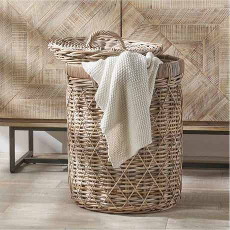 Round brown rattan linen basket, 42cm, with woven lid and handle, holding a folded white knit blanket in a room with a wood-panelled wall.