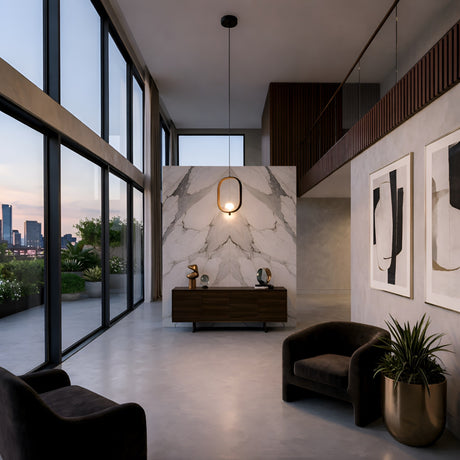 A modern living space with floor-to-ceiling windows, marble accent wall, dark armchairs, abstract art, a potted plant and a terrace city skyline view at sunset—illuminated by the Strappa Pendant Light in Grey/Black.