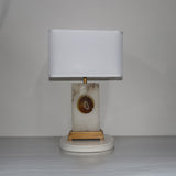 Selune table lamp with rectangular alabaster base, agate slice inset, brushed brass stem and plinth, and white fabric shade.