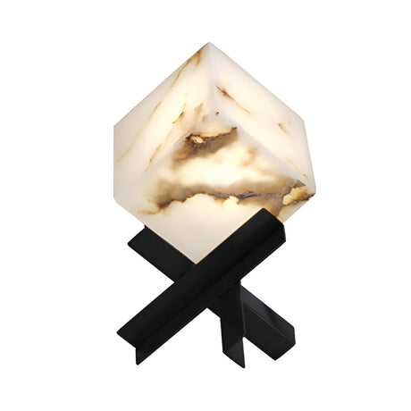 The Kalythra 1 Light Faceted Alabaster Table Lamp features a glowing, cube-shaped soft white alabaster shade with brown veining, supported by intersecting matte black metal legs in an X-shape for a modern geometric look.