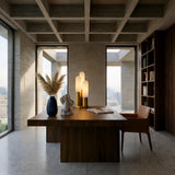 A modern office with a wooden desk, sculptural decor, the Altessa 3 Light Vertical Alabaster Table Lamp in Soft White & Brass, tall lamps, a leather chair, built-in shelves, and large windows that fill the room with natural light.
