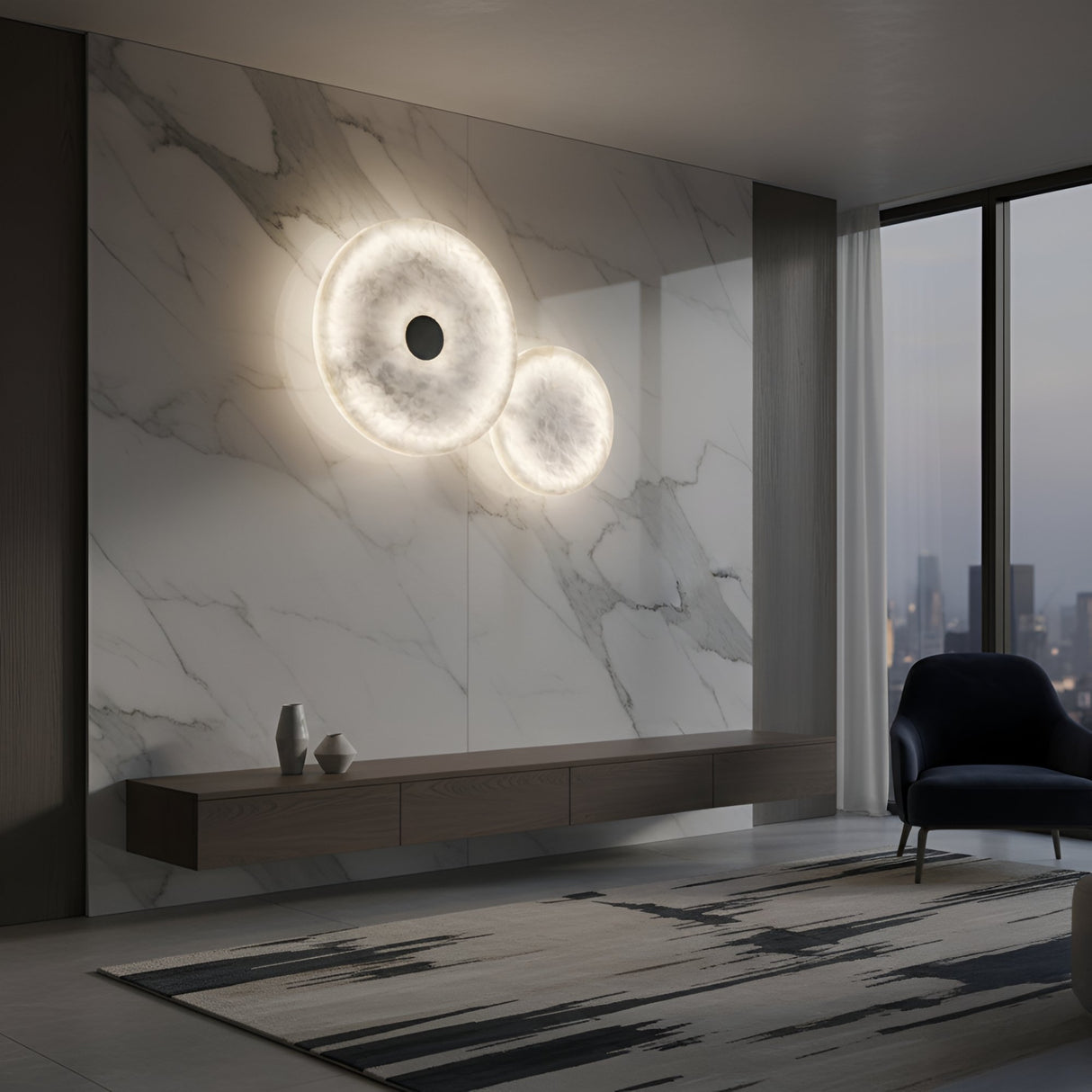 A modern living room with marble walls, a floating wooden console, decorative vases, and the Solmira LED Dual Disc Alabaster Wall Light in soft white & brushed brass. Floor-to-ceiling windows frame a cityscape at dusk. A dark armchair sits by a patterned rug.
