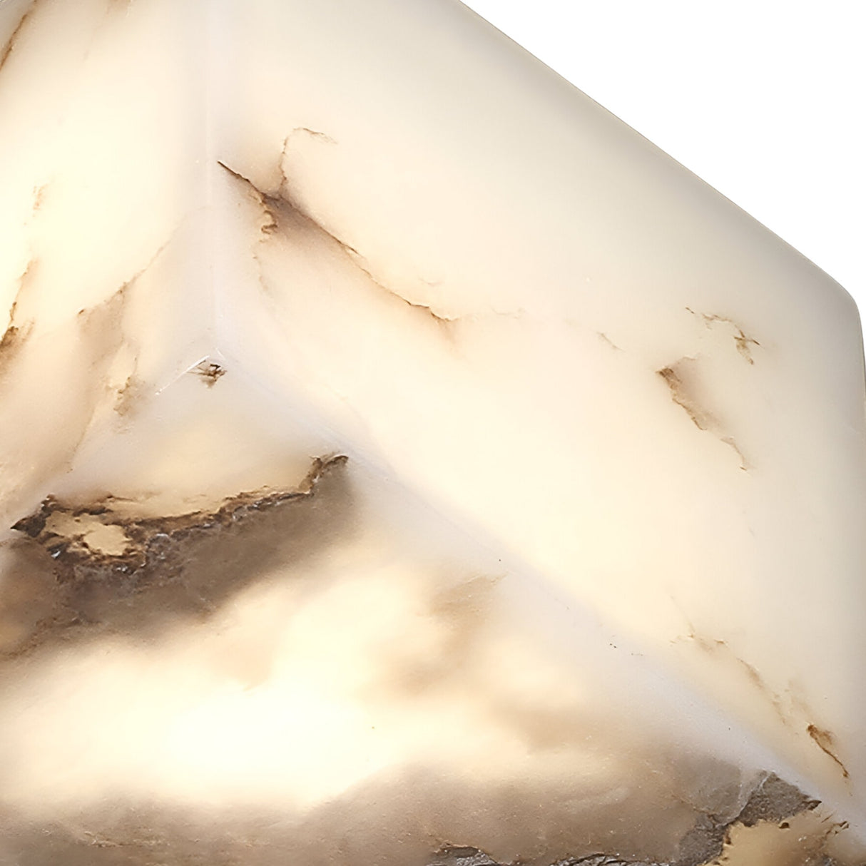 Close-up of the Kalythra 1 Light Faceted Alabaster Table Lamp in Soft White & Matte Black, featuring a creamy white surface with brown marbling, warmly illuminated from within for a glowing effect.