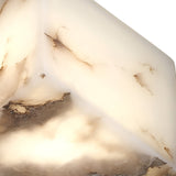 Close-up of the Kalythra 1 Light Faceted Alabaster Table Lamp in Soft White & Matte Black, featuring a creamy white surface with brown marbling, warmly illuminated from within for a glowing effect.