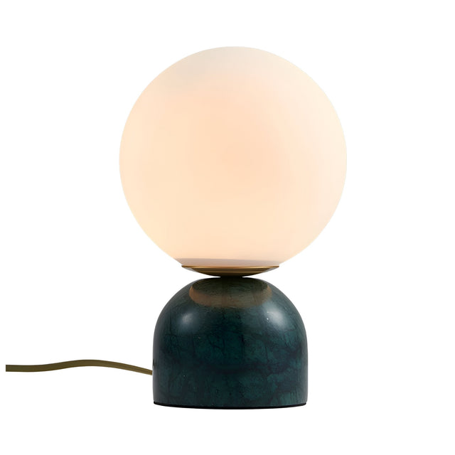 The Verdane LED Globe Alabaster Table Lamp in soft white and green features a round frosted glass globe atop a glossy dark green marble base, shown with an electric cord extending from the base.