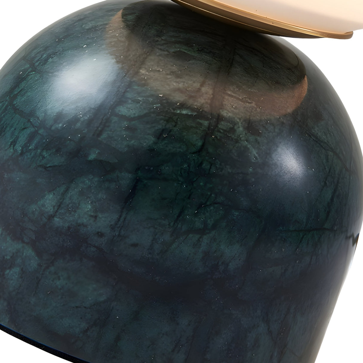 Close-up of a glossy, marbled green and black surface with subtle cracks; a reflective golden disc rests on top—echoing the elegant base design of the Verdane LED Globe Alabaster Table Lamp in Soft White & Green.