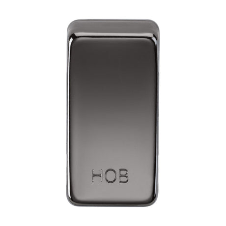 The object is a sleek black nickel switch cover engraved with "HOB" at the bottom. Its reflective, smooth surface and slightly rounded edges contribute to its sophisticated allure, showcasing a dark, shiny silver or chrome appearance.