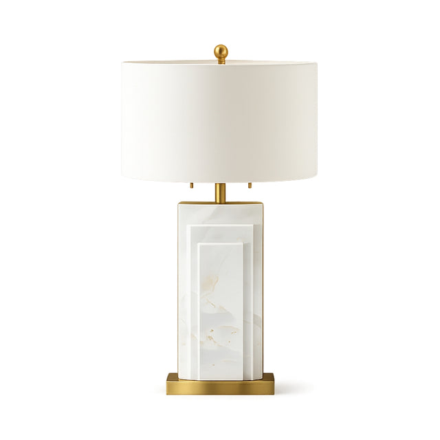 The Caldrin 1 Light Marble Table Lamp features a rectangular white marble base, brass accents, and a cylindrical white shade for a modern, sophisticated look.