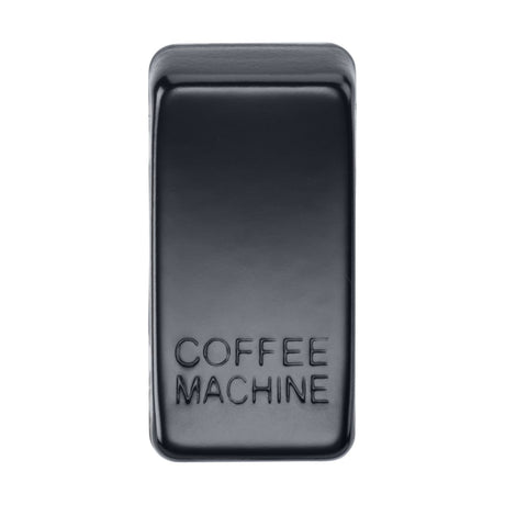 A rectangular matt black switch cover with rounded edges, made from sleek ABS material, prominently displays raised lettering that reads "COFFEE MACHINE" on the front. The surface presents a smooth and glossy appearance.