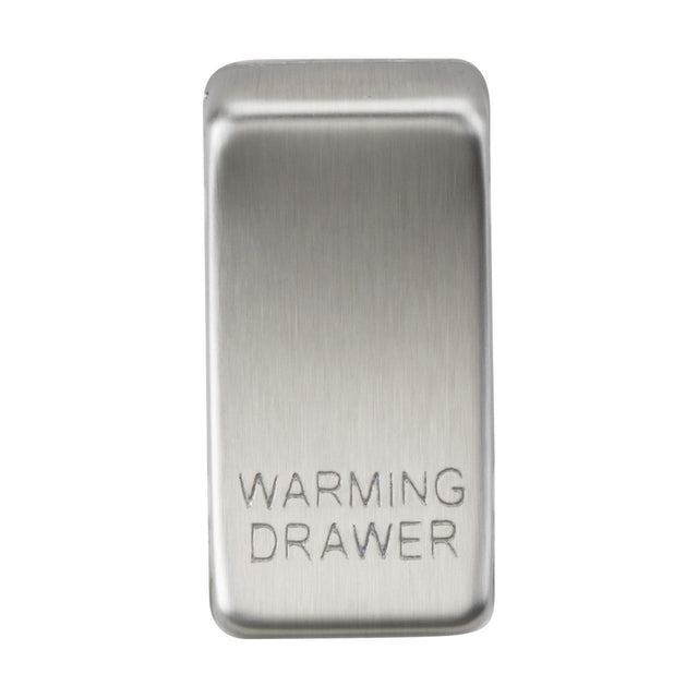 Close-up of a brushed chrome switch cover with "Marked WARMING DRAWER" engraved on it. The stainless steel surface enhances its sleek, rectangular shape, subtly reflecting light.