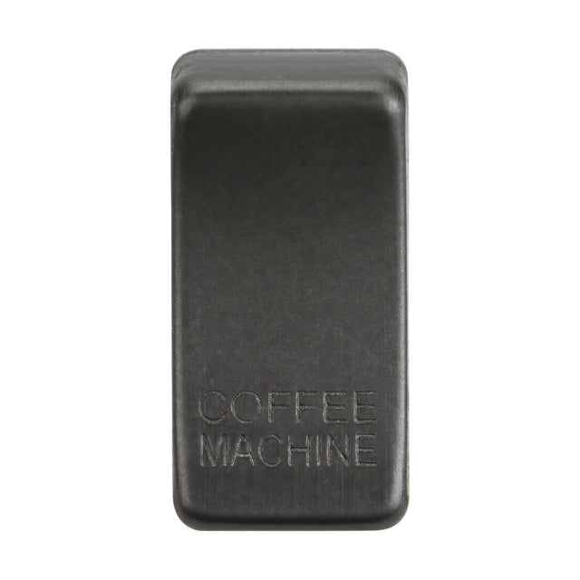 The Switch Cover "Marked COFFEE MACHINE" in smoked bronze has a rectangular shape and resembles a sleek rocker cover in both design and durability when viewed from above.
