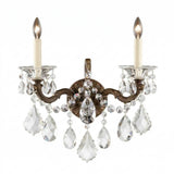 The Vienna 2 Light K9 Crystal Wall Light features two candle-style bulbs, ornate bronze arms, and hanging K9 crystal pendants for a luxurious Rococo accent that adds elegance and sparkling light to any space.