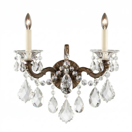 The Vienna 2 Light K9 Crystal Wall Light features two candle-style bulbs, ornate bronze arms, and hanging K9 crystal pendants for a luxurious Rococo accent that adds elegance and sparkling light to any space.