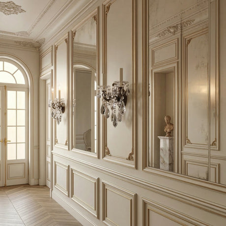 Elegant hallway features ornate cream wall panels, large mirrors, and Rococo lighting with the Vienna 2 Light K9 Crystal Wall Light. A marble pedestal displays a classical bust as sunlight pours through a tall arched glass-panel door.