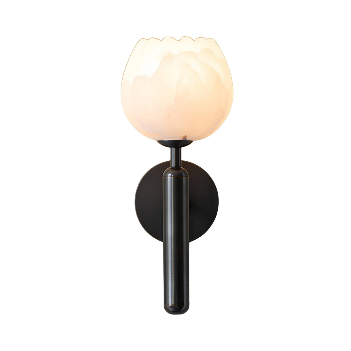 The Olivaro 1 Light Pedal Form Alabaster Wall Light features a soft white, tulip-shaped shade and matte black base, illuminated and mounted on a white background.