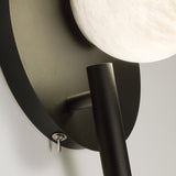 Close-up of the Halvessa LED Alabaster Wall Light with Reading Light in Black, showing the textured round iron backplate, angled reading arm, and glowing alabaster globe.