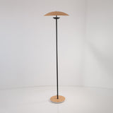 The Ex-Display Ginger LED Floor Lamp in black and oak features a slim black pole, round wooden base, and matching disc-shaped wooden shade, standing elegantly against a plain white background.