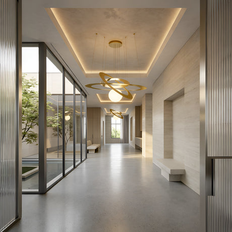 A modern hallway with beige walls, built-in benches, large windows opening to greenery, and a Universe LED Suspension Light - Matte Gold hanging from recessed ceilings for a bright, elegant touch.
