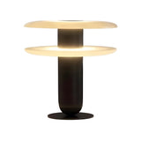 The Luxelle LED Double Tiered Alabaster Table Lamp features a cylindrical black base and two wide, flat circular shades in soft white, stacked one above the other for a modern look and warm illumination.
