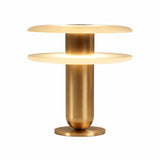 The Luxelle LED Double Tiered Alabaster Table Lamp in Soft White & Brass features a cylindrical gold base and dual circular shades, offering a sleek, minimalist look. When lit, it casts a warm, inviting glow.