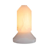 The Lumorin 1 Light Sculpted Alabaster Table Lamp - Soft White features a cylindrical design with stepped geometric details, crafted from natural Spanish alabaster, emitting a warm glow, and shown against a plain white background.