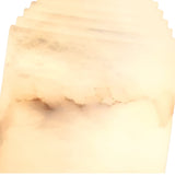 A close-up of the Lumorin 1 Light Sculpted Alabaster Table Lamp—Soft White reveals translucent, cream-toned Spanish alabaster with subtle brown and gray veining, creating its smooth, layered look.
