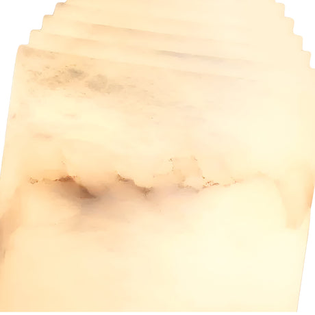 A close-up of the Lumorin 1 Light Sculpted Alabaster Table Lamp—Soft White reveals translucent, cream-toned Spanish alabaster with subtle brown and gray veining, creating its smooth, layered look.