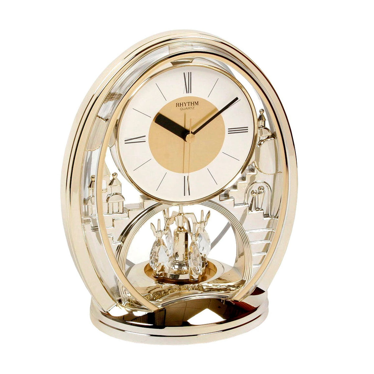 Oval mantel clock in gold-tone plastic with a double oval frame, white Roman numeral dial, castle-scene detailing, and a crystal rotating pendulum, shown on a plain white background.