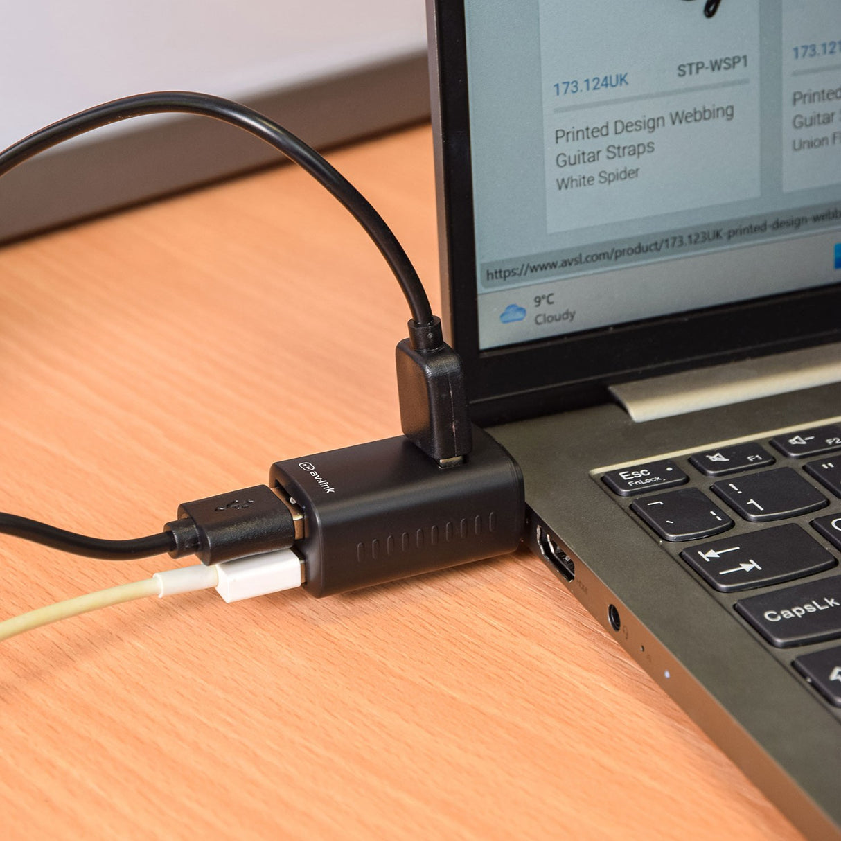 AV:Link 3 Port Mini USB-C Hub in matt black plugged into a laptop with USB-A cables connected, shown on a wooden desk.