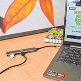 AV:Link 4-Port USB 3.2 Type-C Hub in brushed black connected to a laptop on a desk, with USB-A and USB-C ports labelled along the side.