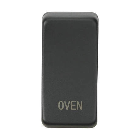 An anthracite Switch Cover "Marked OVEN" with a sleek black rectangular design and white text is displayed on a pristine white background. This cover is engineered for flexibility, offering interchangeable rocker covers for simple customization.