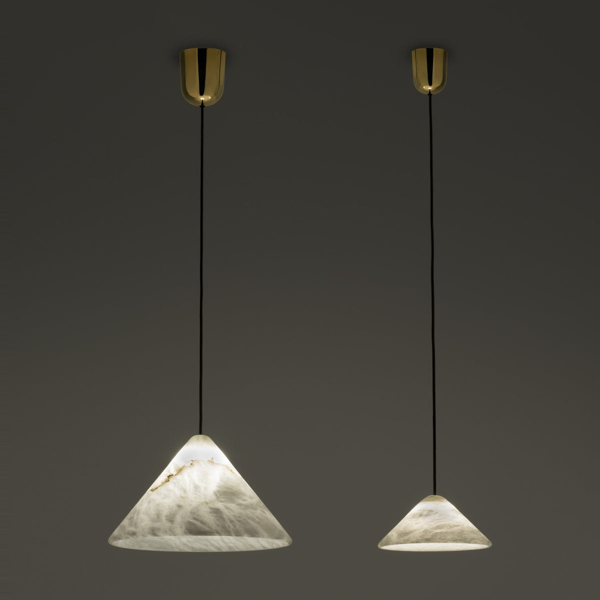 Fuji LED Alabaster Dimmable Pendant Light in two sizes, cone-shaped alabaster shades with grey veining on black flex and polished brass ceiling canopies, shown lit against a dark background.