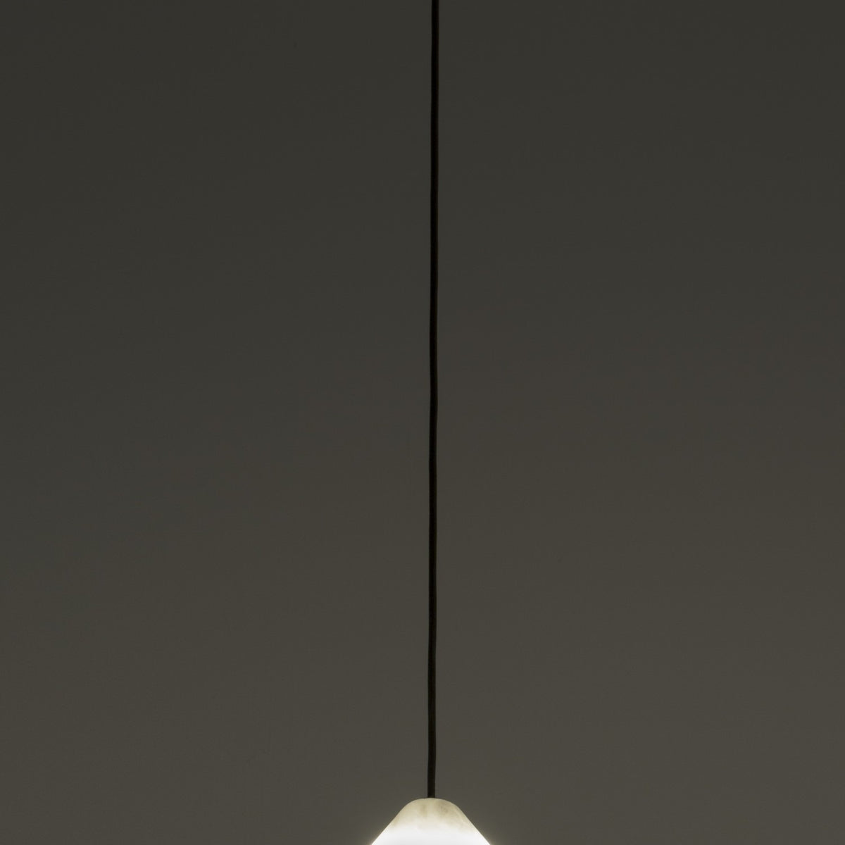 Fuji LED Alabaster Dimmable Pendant Light in Polished Brass, showing the cone-shaped alabaster shade glowing softly on a slim black flex against a plain grey background.