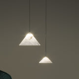 Fuji LED Alabaster Pendant Light in two sizes, cone-shaped white stone shades on slim black cords, glowing warmly against a muted grey background.