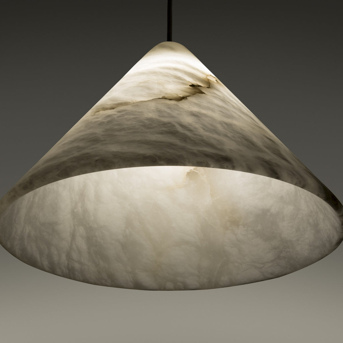 Fuji LED Alabaster Pendant Light with a cone-shaped white alabaster shade showing grey veining, illuminated from within, hung on a slim black cord.