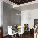 Yarvelle 19 Light Glass Pendant Light in chrome, clustered clear glass teardrop shades on thin wires, shown above a glass dining table in a modern grey and white dining room.