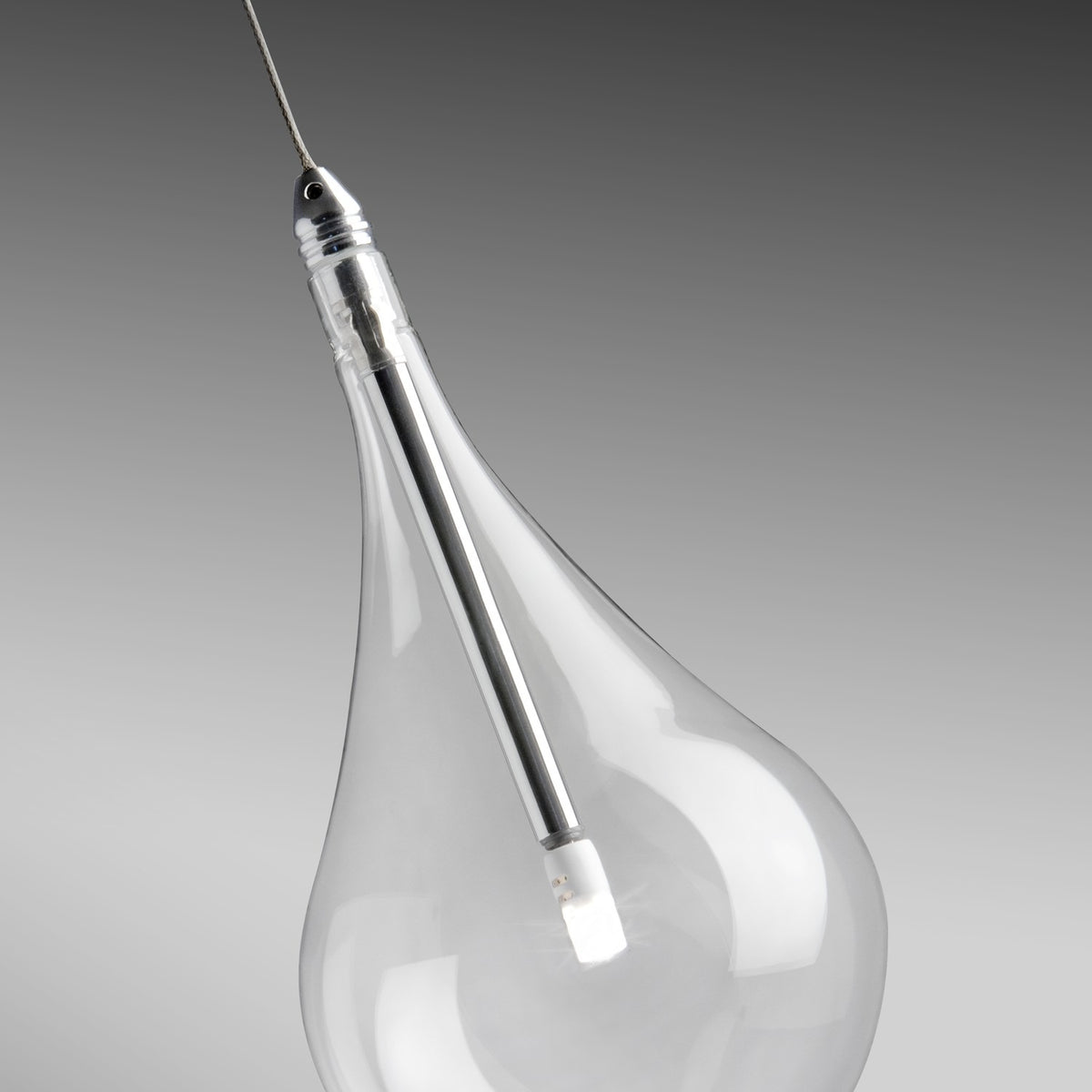 Close-up of the Yarvelle glass pendant light showing a clear teardrop-shaped shade with a slim chrome holder and G4 bulb, set against a grey background.