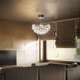 Yarvelle 37 Light Glass Pendant Light with 70cm Drop in chrome, clustered clear glass teardrop globes hung above a sofa in a living room with brown roman blinds.