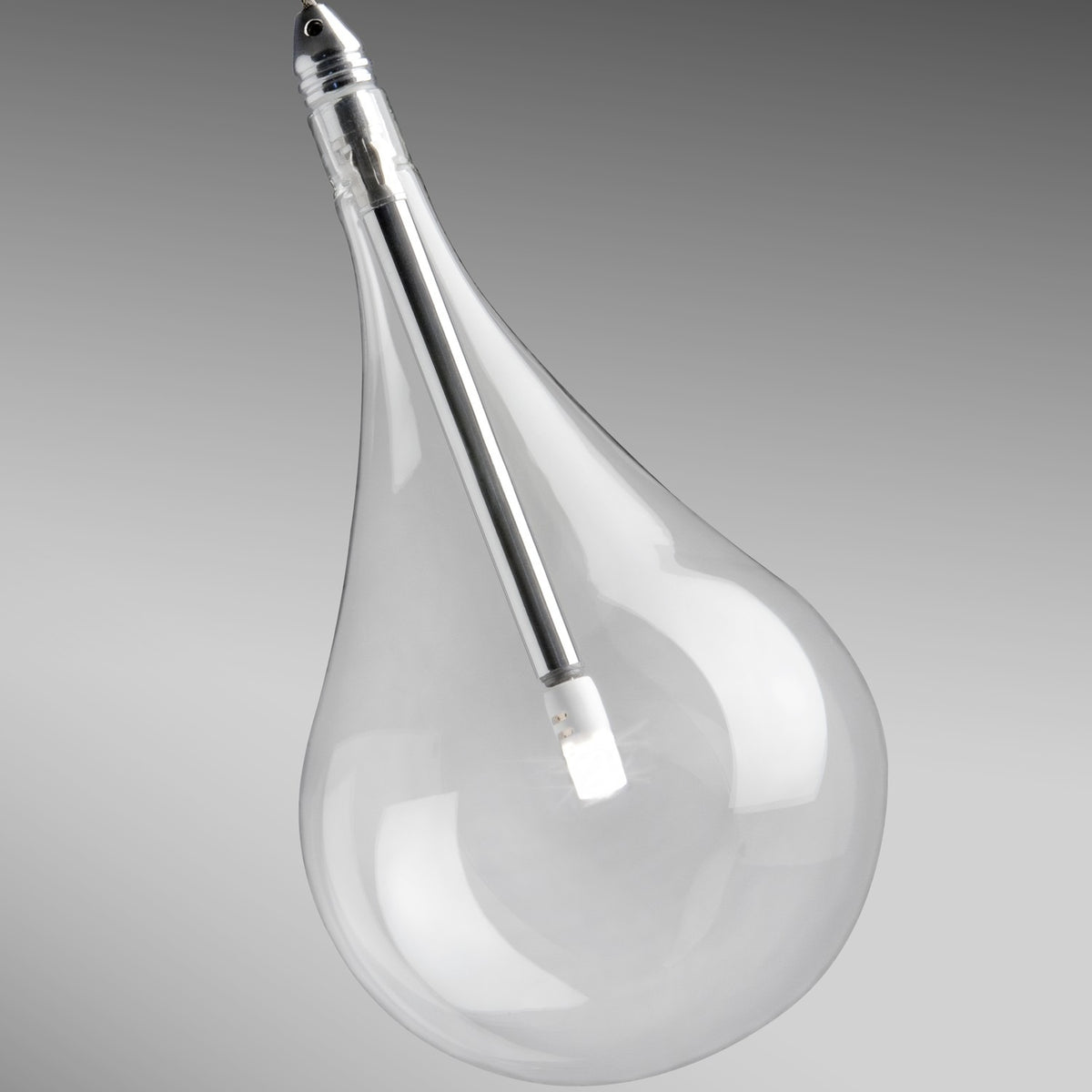 Close-up of a single clear glass teardrop shade from the Yarvelle 16 light pendant, with chrome cap and slim internal stem, set against a plain grey background.