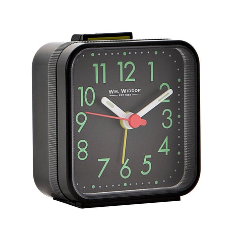 Square plastic alarm clock in black with a top shut-off button, featuring green Arabic numerals, white hands, and red and yellow accent hands on a black dial, shown on a plain white background.