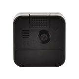Rear view of the square black plastic alarm clock, showing the top snooze/shut-off button, rear speaker grille, control dial, battery compartment, and CE marking, on a plain white background.