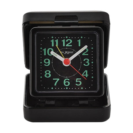 Square quartz travel alarm clock in a black plastic fold-open case, with a black luminous dial, green numerals, white hands and a red second hand, shown on a plain white background.